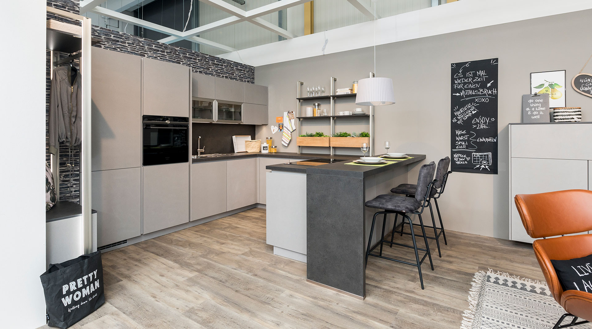 Platzbietende U-Küche mit passenden Wohnmöbeln "Cemento" von Nobilia